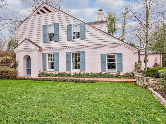 view of front of house with a chimney and a front yard