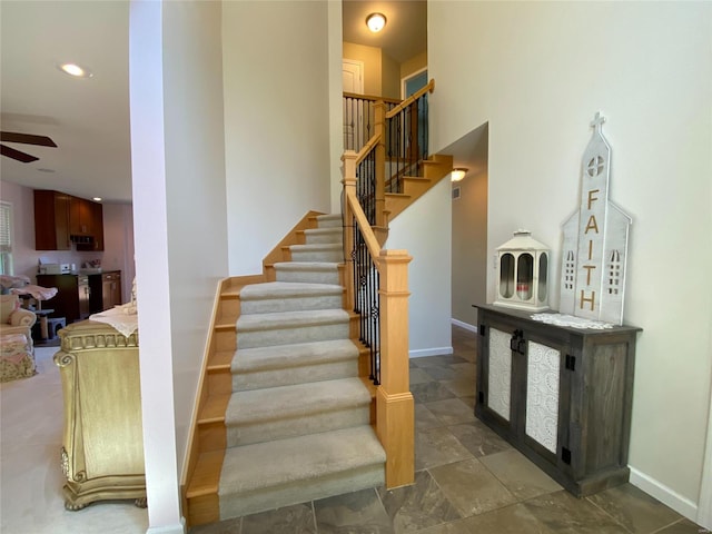 staircase featuring ceiling fan