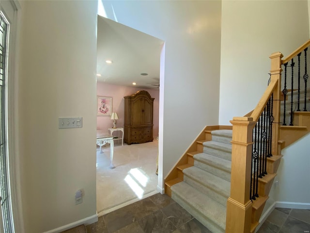 stairway featuring ceiling fan