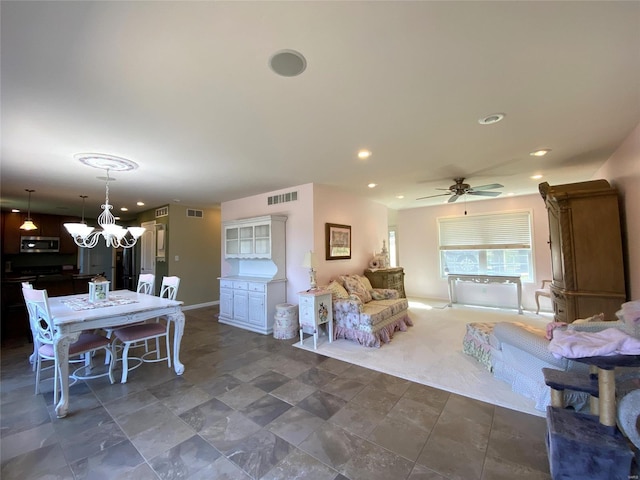 living room featuring ceiling fan with notable chandelier