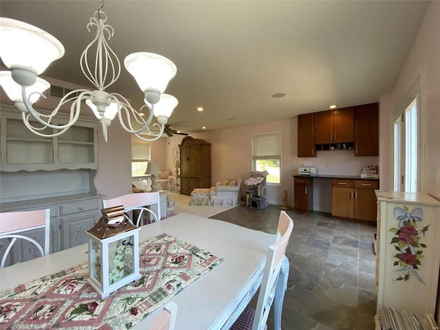 dining room featuring ceiling fan with notable chandelier