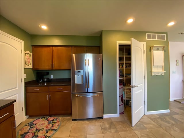 kitchen featuring light tile patterned floors and stainless steel fridge with ice dispenser