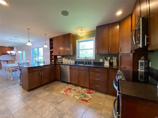 kitchen with kitchen peninsula, hanging light fixtures, light tile patterned flooring, sink, and stainless steel appliances