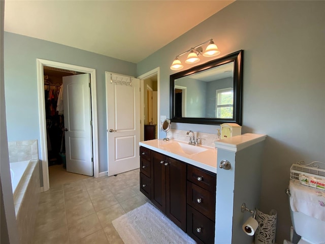 bathroom with vanity, a relaxing tiled tub, and tile patterned floors