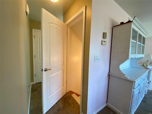 hallway with dark tile patterned flooring