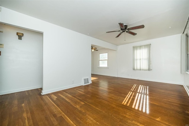 spare room with a ceiling fan, baseboards, visible vents, and wood finished floors