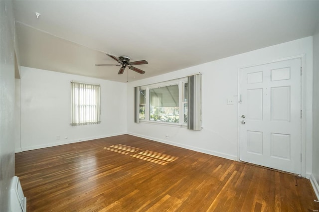 spare room featuring a baseboard radiator, ceiling fan, and dark hardwood / wood-style flooring