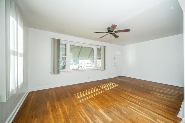 unfurnished room featuring baseboards, ceiling fan, and wood finished floors