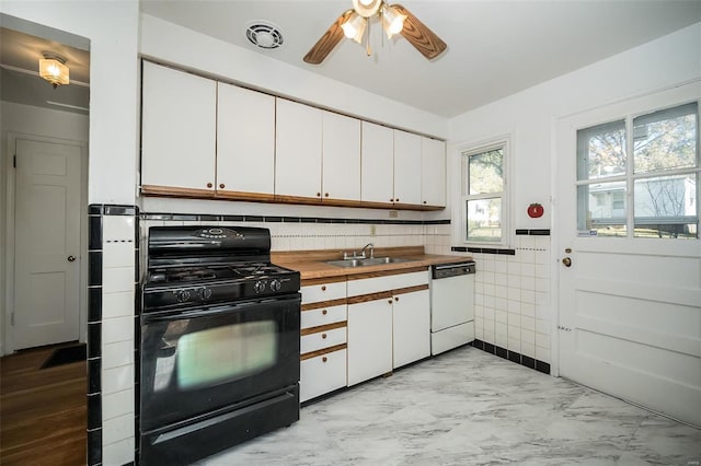 kitchen featuring dishwasher, butcher block counters, black range with gas stovetop, sink, and white cabinets