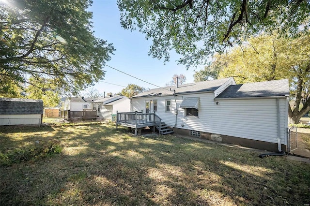 rear view of property featuring a deck and a yard