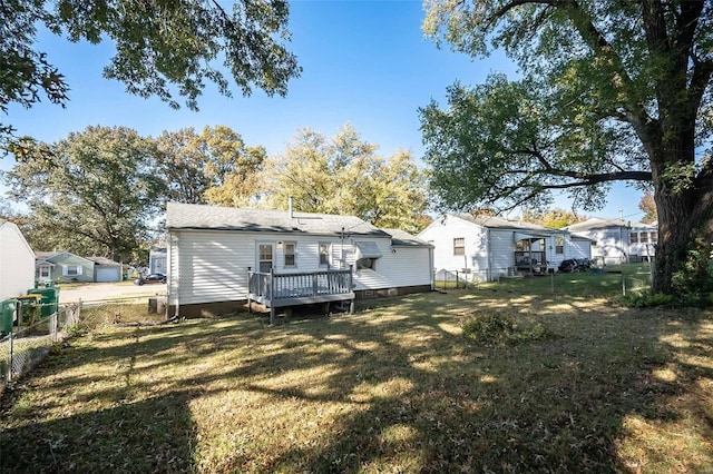 back of property with a deck and a lawn