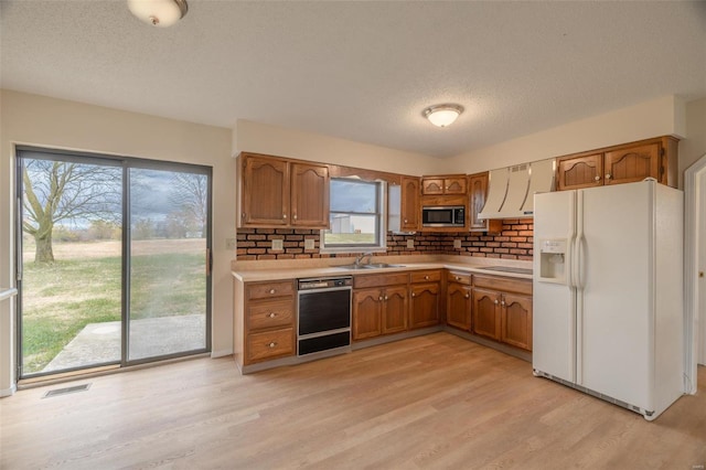 kitchen with black dishwasher, white fridge with ice dispenser, stainless steel microwave, and plenty of natural light