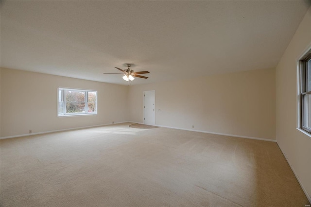 spare room with light colored carpet and ceiling fan