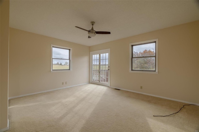 carpeted spare room featuring ceiling fan