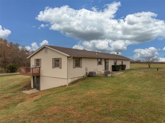 rear view of house with a wooden deck, cooling unit, and a yard