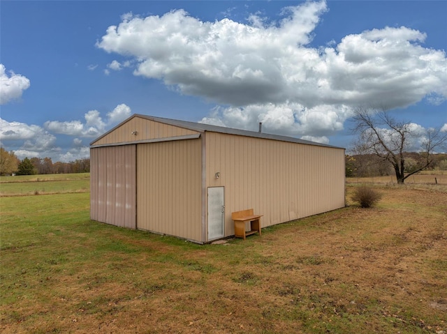 view of outdoor structure with a lawn and a rural view