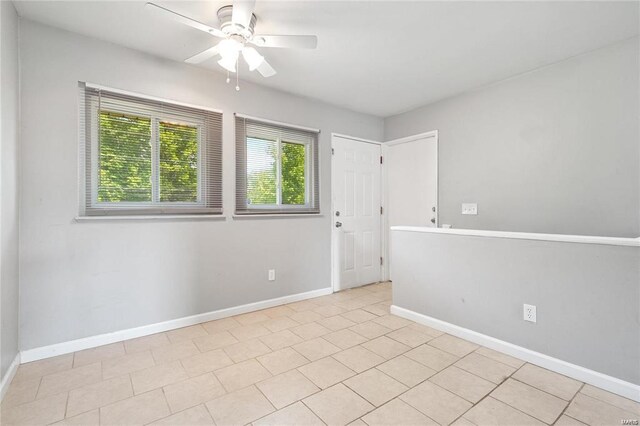 tiled spare room with ceiling fan