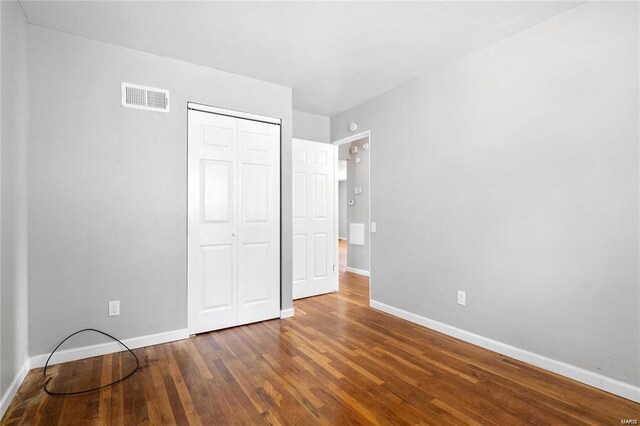 unfurnished bedroom featuring a closet and wood-type flooring