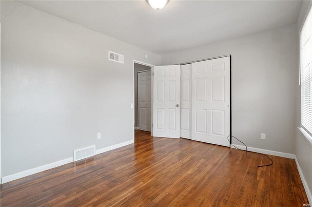 unfurnished bedroom with wood-type flooring and a closet