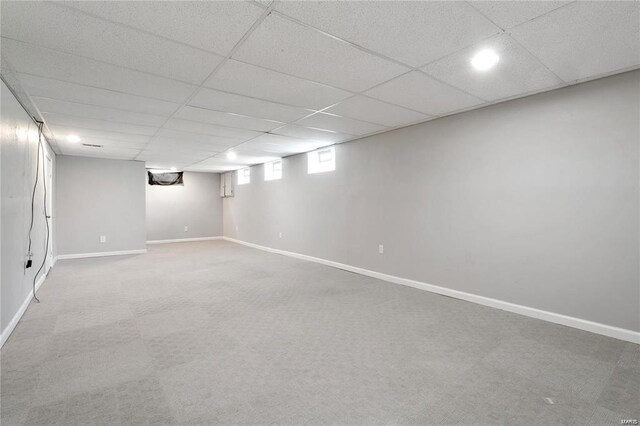 basement featuring carpet floors and a paneled ceiling