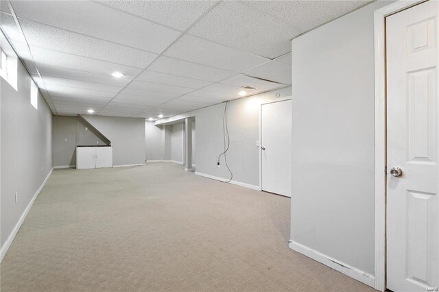 basement with light carpet and a drop ceiling