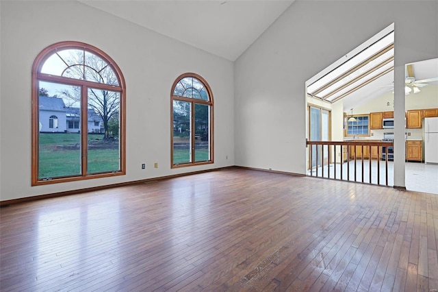 interior space with high vaulted ceiling, wood-type flooring, and ceiling fan