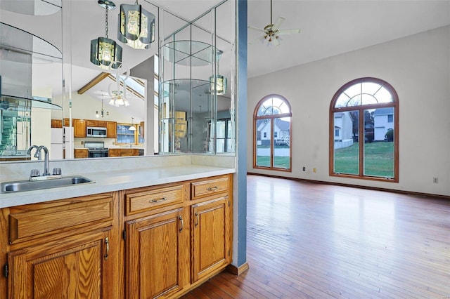 kitchen featuring light wood-type flooring, sink, ceiling fan, and white fridge