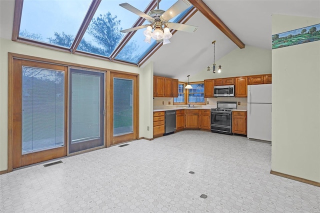 kitchen with stainless steel appliances, decorative light fixtures, sink, beamed ceiling, and ceiling fan