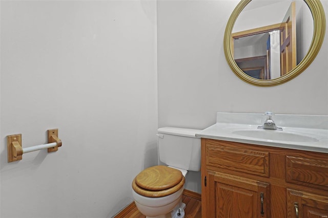 bathroom featuring toilet, vanity, and wood-type flooring