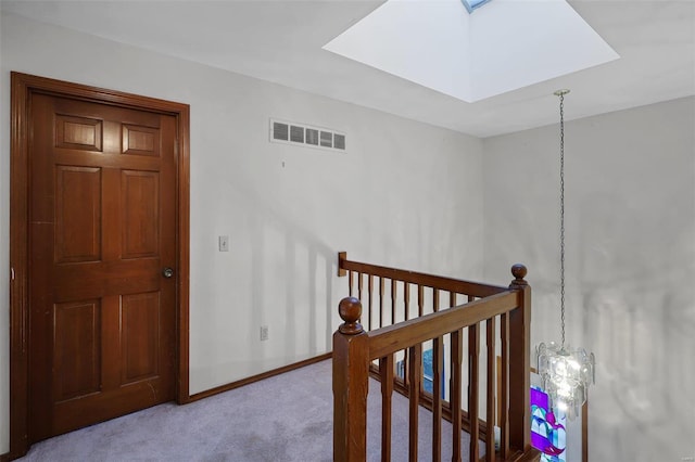 stairway featuring a skylight and carpet floors