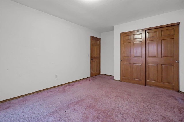 unfurnished bedroom featuring light carpet and a closet