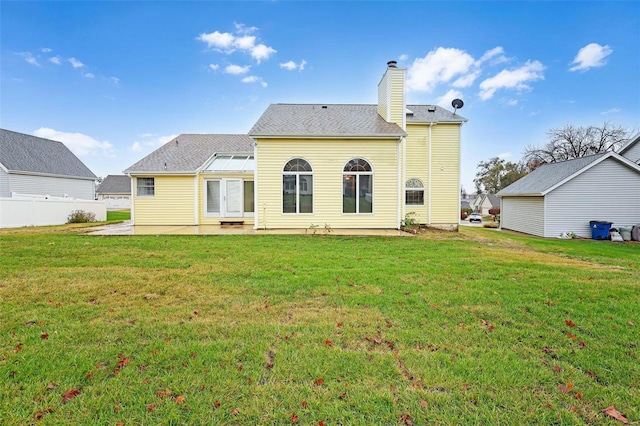 back of property with a patio area and a lawn