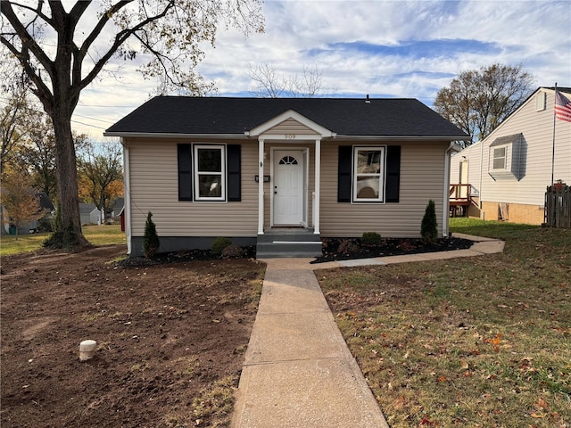 bungalow-style home with a front yard