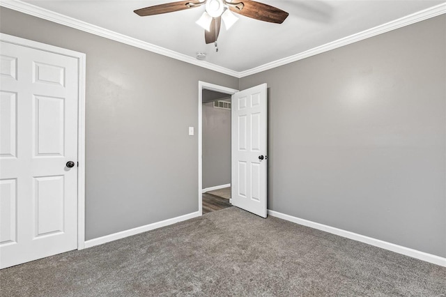 unfurnished bedroom featuring ceiling fan, crown molding, and dark carpet