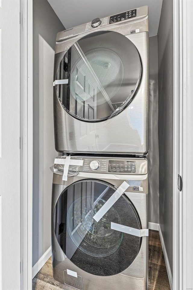 washroom featuring stacked washing maching and dryer and hardwood / wood-style flooring