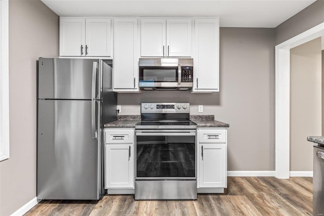 kitchen with dark hardwood / wood-style flooring, white cabinetry, and appliances with stainless steel finishes