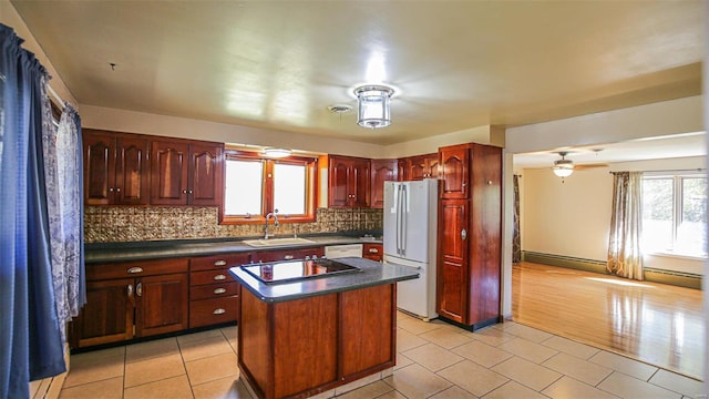 kitchen featuring white appliances, sink, plenty of natural light, and a kitchen island