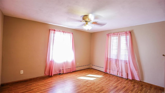 unfurnished room with light hardwood / wood-style flooring, a baseboard heating unit, plenty of natural light, and ceiling fan