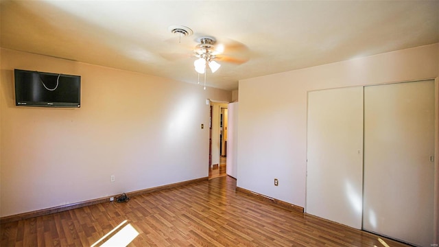 unfurnished bedroom featuring a closet, hardwood / wood-style flooring, and ceiling fan