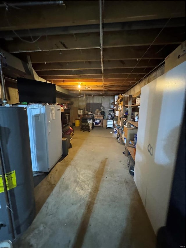 basement featuring fridge and gas water heater