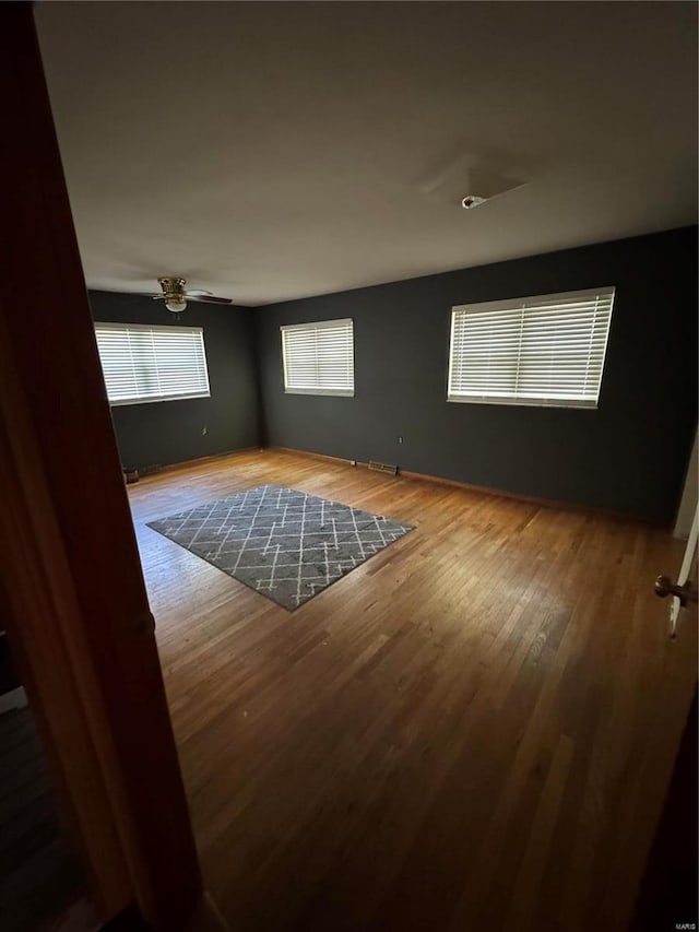 unfurnished room with hardwood / wood-style flooring and ceiling fan