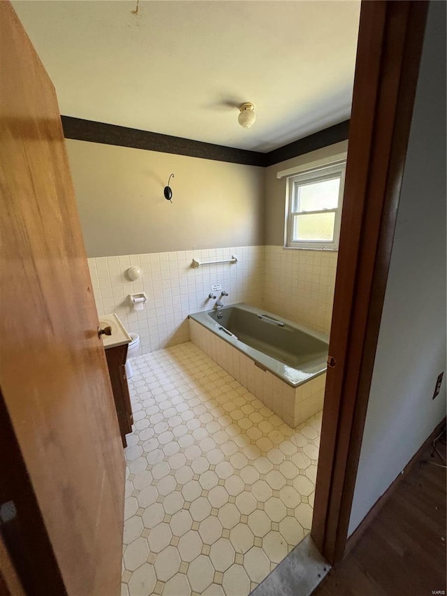 bathroom featuring vanity and tiled bath