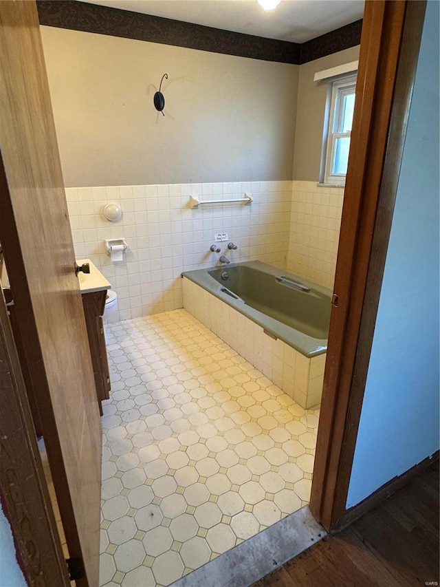 bathroom with toilet, wood-type flooring, a washtub, and tile walls