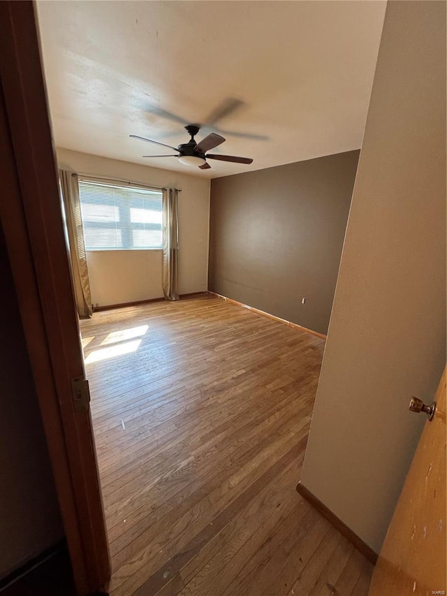 empty room with light hardwood / wood-style flooring and ceiling fan