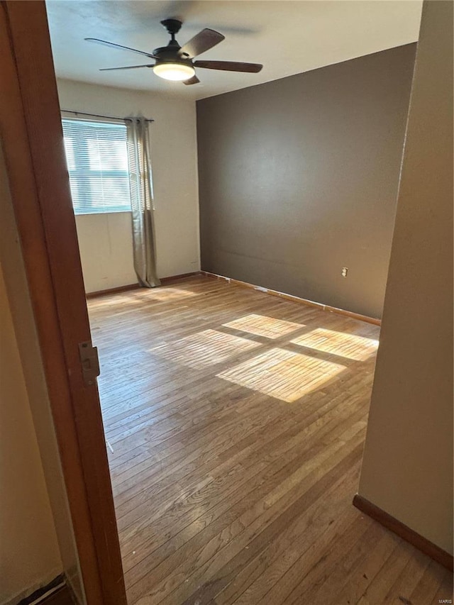 empty room with ceiling fan and light wood-type flooring