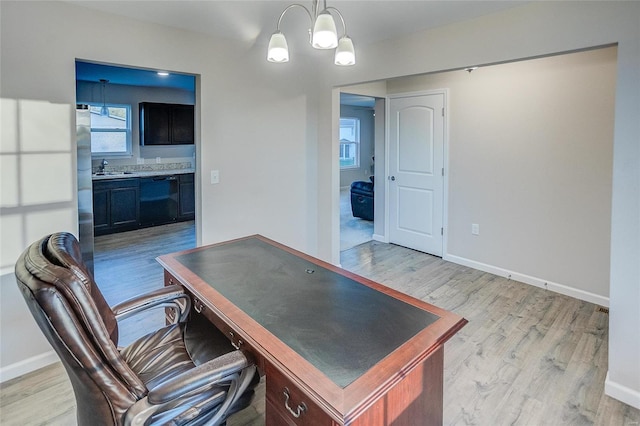 office area featuring light hardwood / wood-style floors, an inviting chandelier, and sink