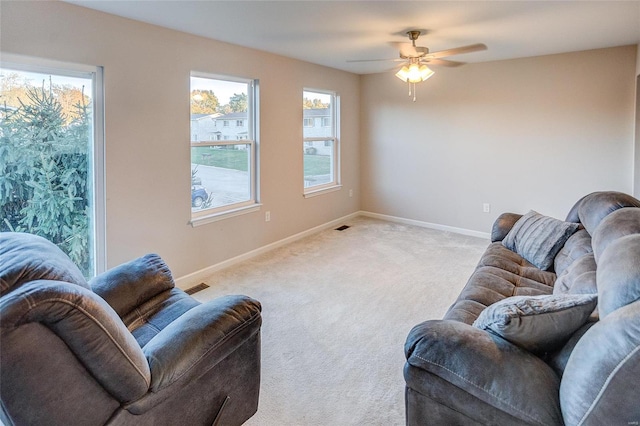 carpeted living room featuring ceiling fan