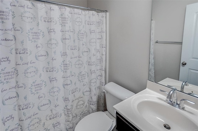 bathroom featuring vanity, curtained shower, and toilet