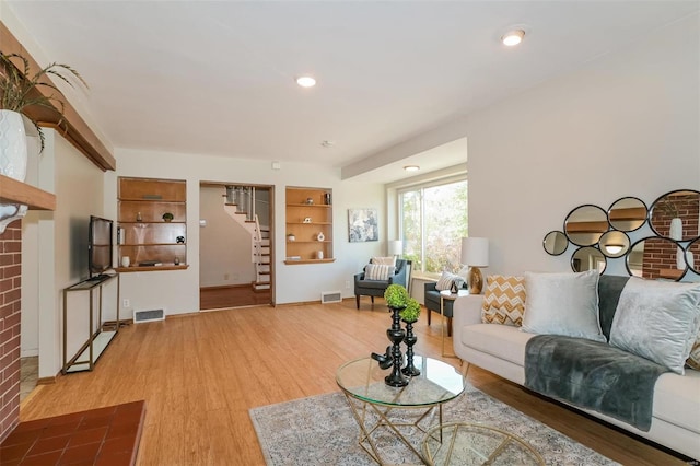 living room with hardwood / wood-style floors and a brick fireplace