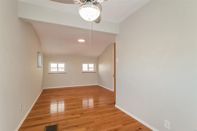 empty room featuring vaulted ceiling and light hardwood / wood-style flooring